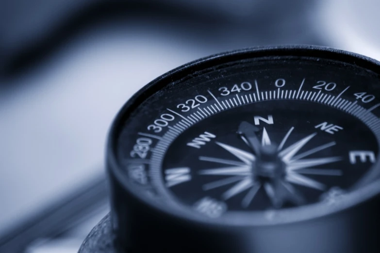 an analog compass sitting on top of a desk