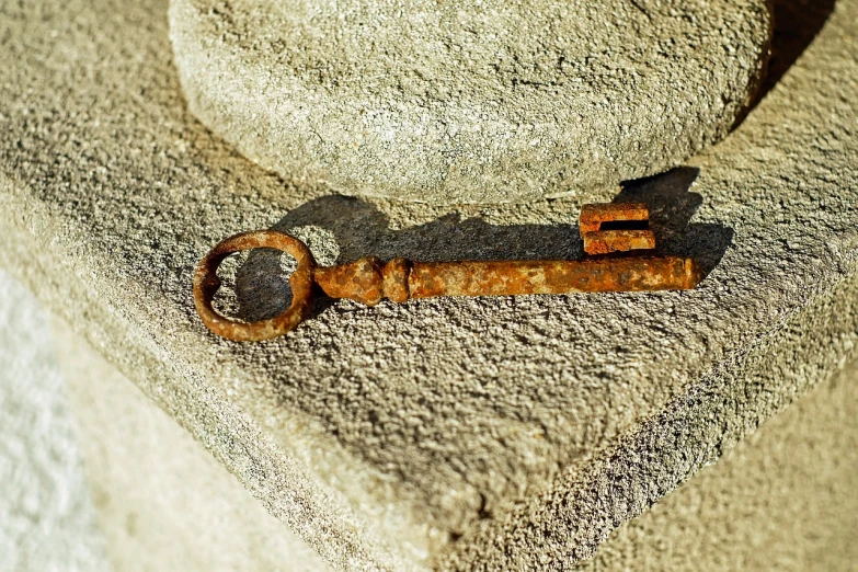 the old rusty key is still stuck in the concrete