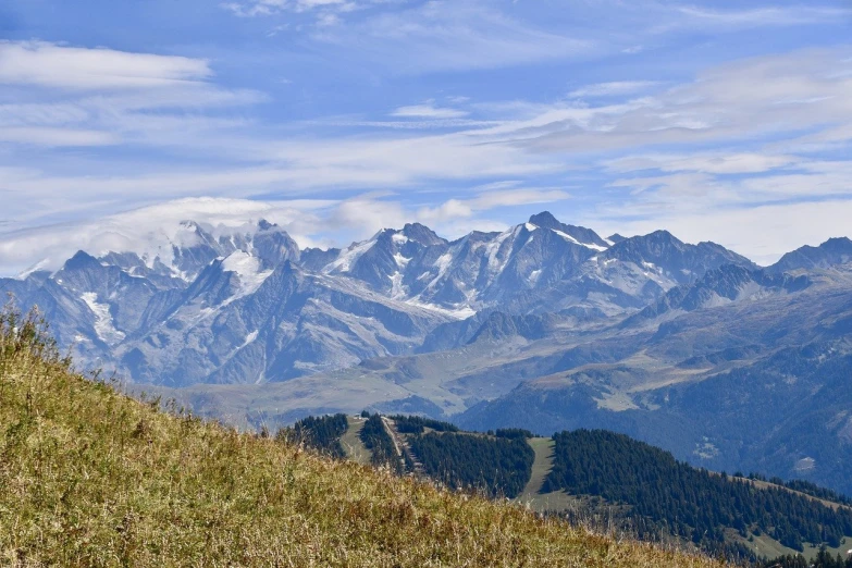 a bench sitting on a hill overlooking mountains and forests