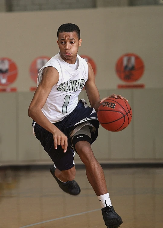 the man is running for the basketball in an indoor gym