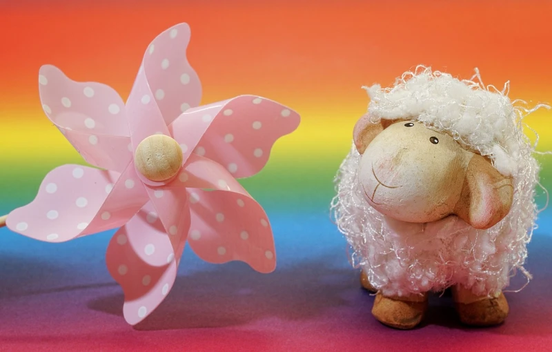 the sheep is near the pink flower and one is very colorful