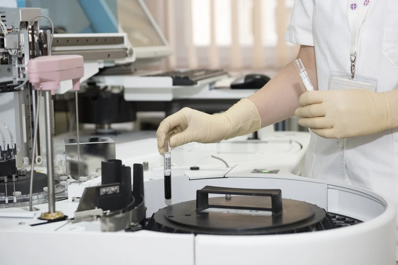 a doctor wearing gloves and sterile clothing is preparing medical equipment