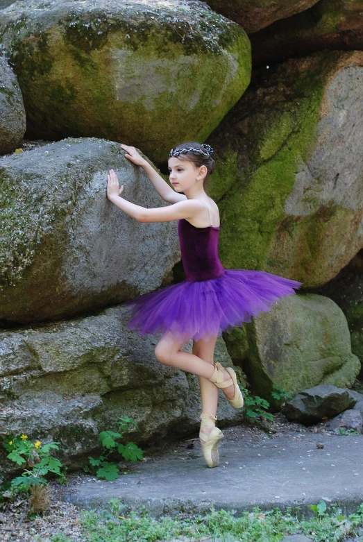 the girl is dressed in an old fashion ballerina outfit and posing for the camera