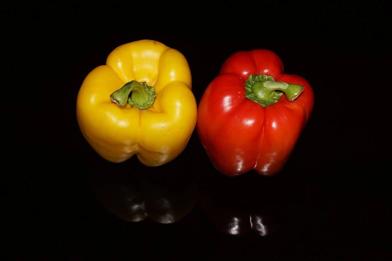 two peppers are standing close to one another