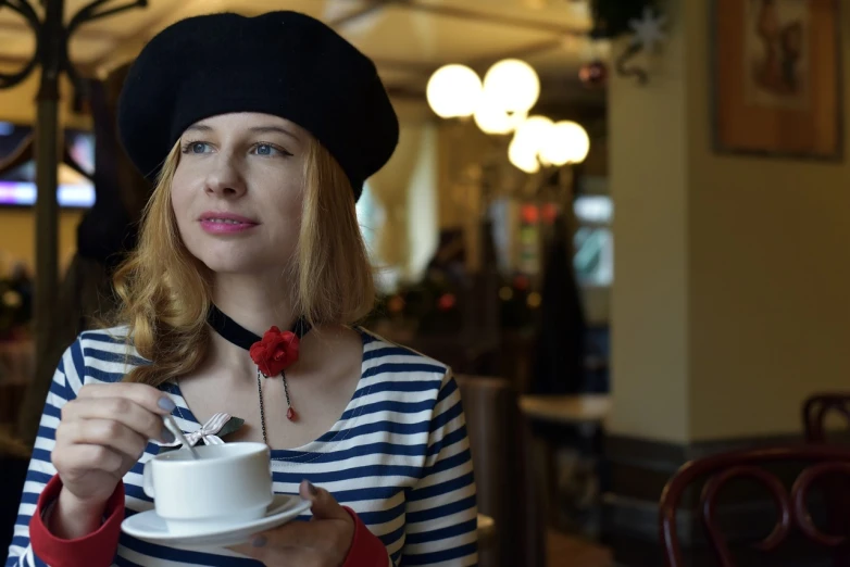 the woman is enjoying her beverage in a cafe