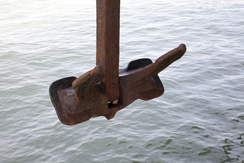 a rusty boat tie with water and sky in background