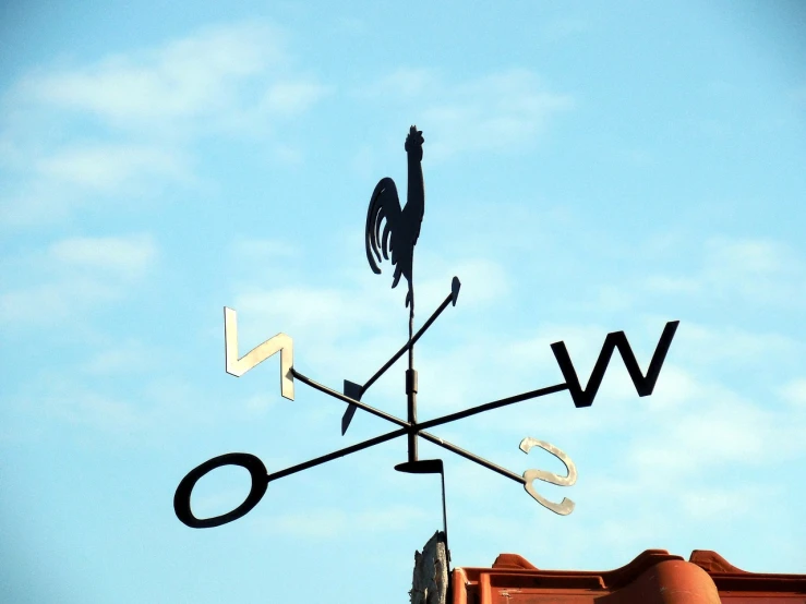 a weather vane with the word w o on it's side