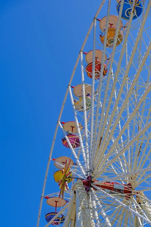 a ferris wheel against the blue sky on a sunny day