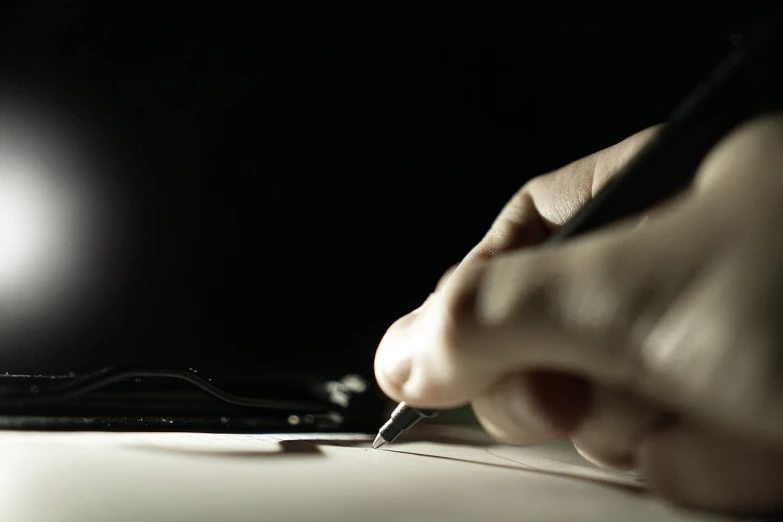 a person with a pen and in a dark room