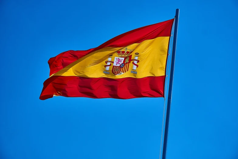 an spanish flag flies high in the sky