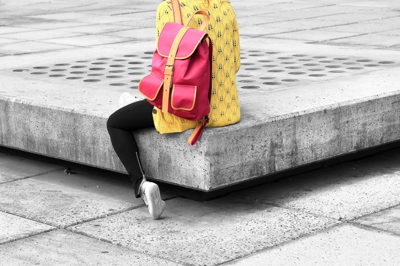 a woman is sitting on a cement wall with her back to the camera