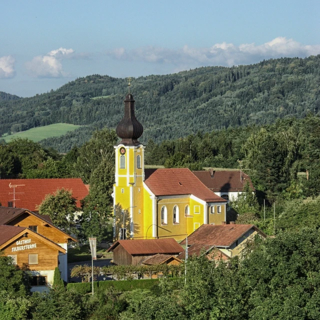 a church near some trees on a hillside