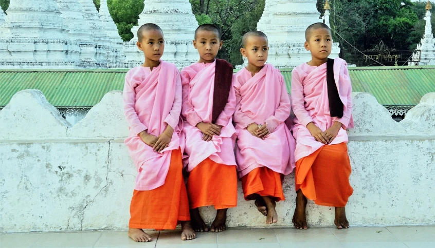 three girls sitting next to each other on the ground