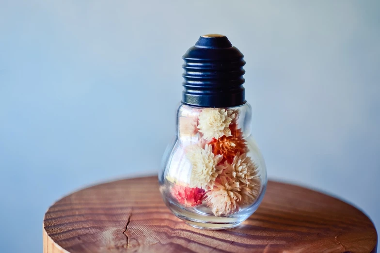 a small glass bulb sitting on top of a wooden stand