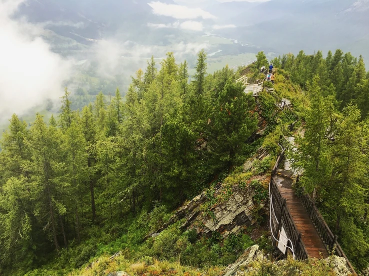 a view of several people on a train track on a mountain side