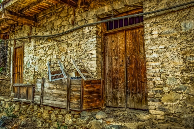 an old stone house with wood shutters and open doors