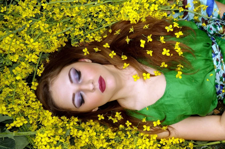 a woman lying down in a field of flowers