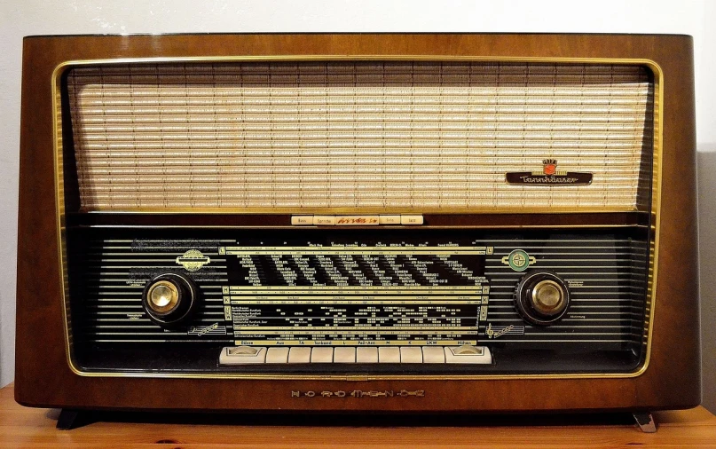 an old radio sits on a wood surface