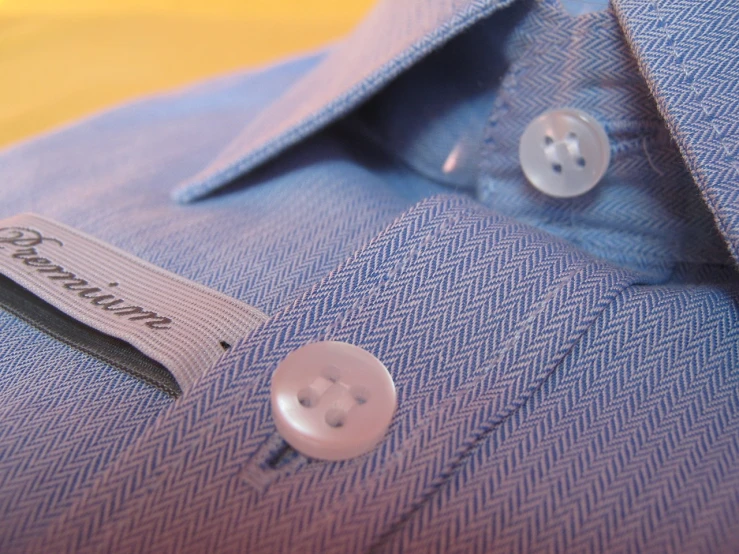 a blue dress shirt with ons and a name tag