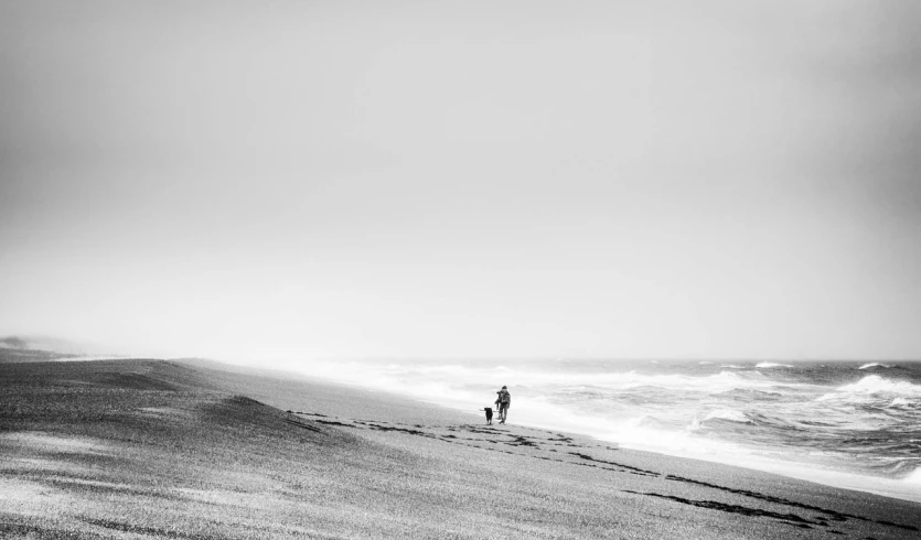 a man walking along the beach in the sand