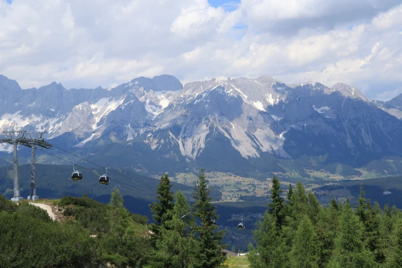 the sky lift is high above a valley and mountain range