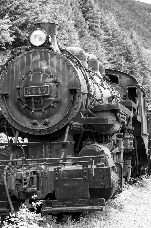 a black and white image of a locomotive train in motion on the tracks