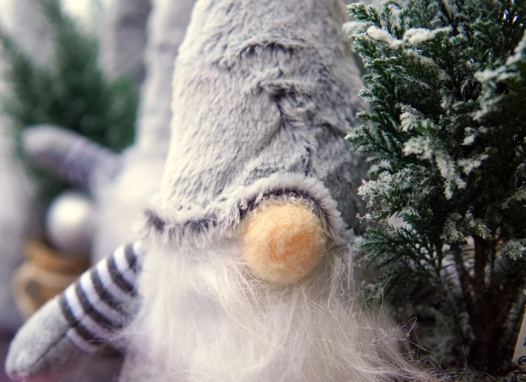 a stuffed gray and white animal near some trees