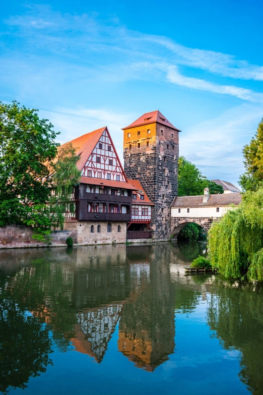 a castle like building next to water and trees