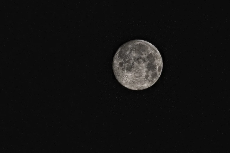 the moon in the dark night sky is almost hidden