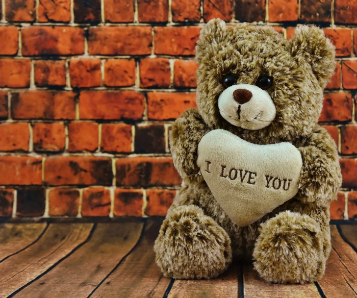 a teddy bear is holding onto a heart