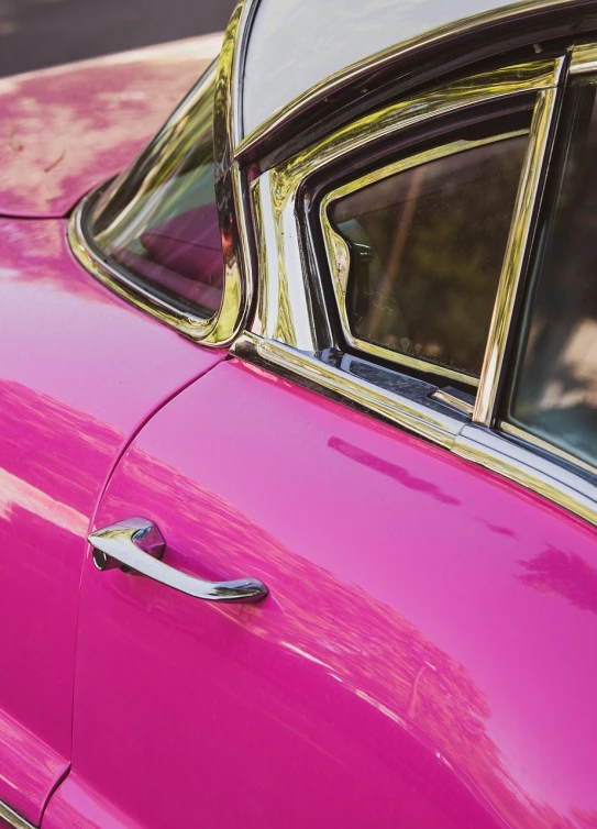 pink cars are parked in a lot near the curb