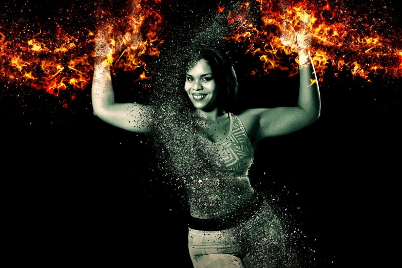 a girl holds two arms in the air as she is sprayed by water