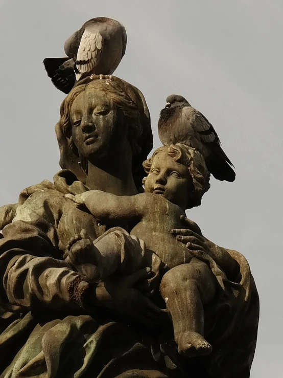 a statue with two vultures on it with another sitting on top