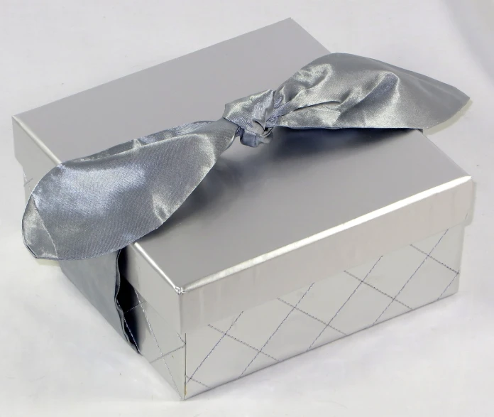 an empty silver box with a ribbon on the top