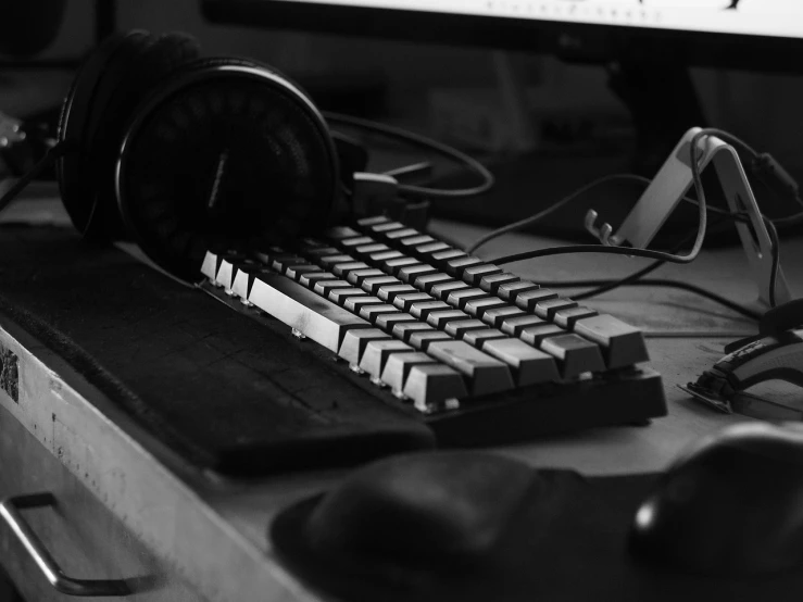 a keyboard and headphones sitting in front of a computer