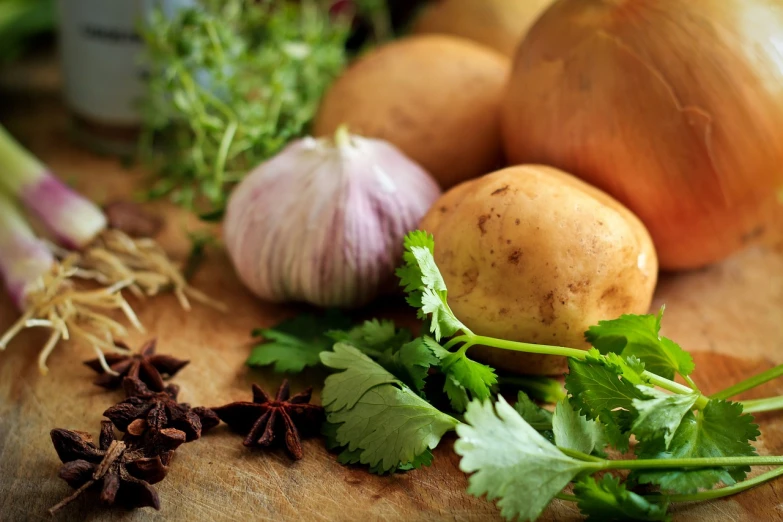 a wooden  board topped with herbs and a group of potatoes