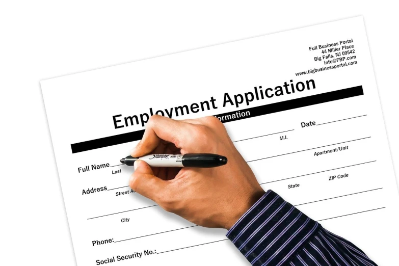 a person in suit writing on a job application form