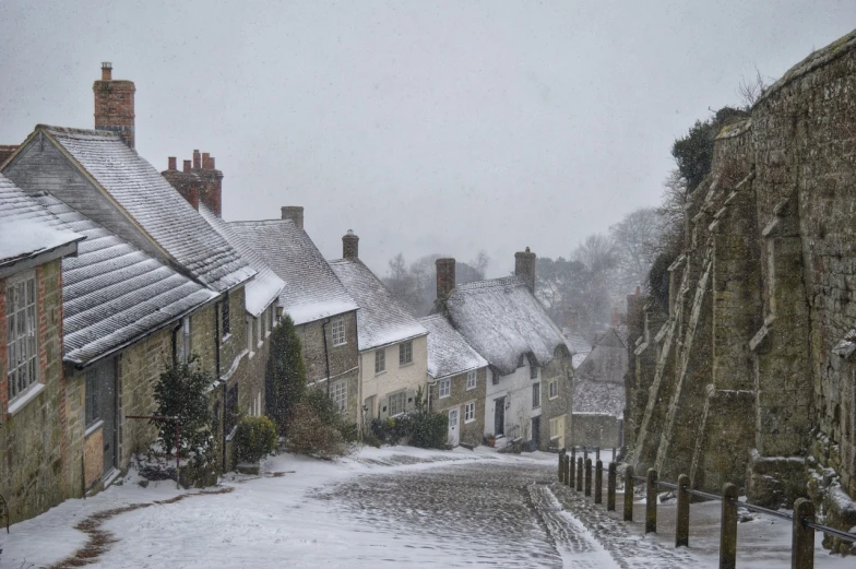 a street is covered in snow by buildings