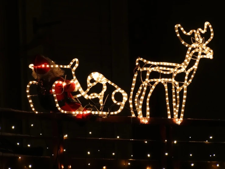 a santa clause sleigh lit up with christmas lights