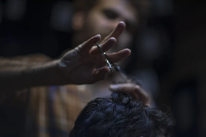 a man sitting in front of a mirror getting his hair cut