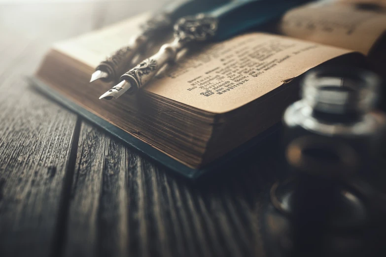 an open book on a table with pen and ink