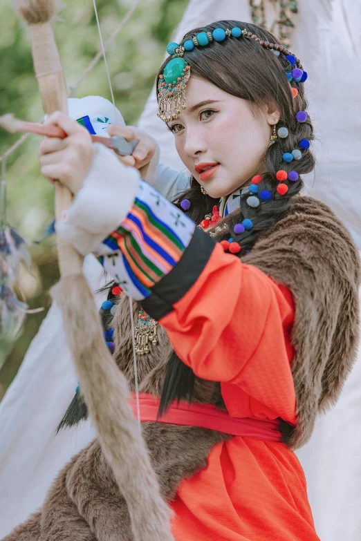 a girl wearing a costume holds on to her arrows