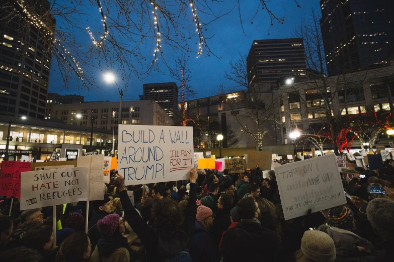 an occupy protest rally in city at night with lit up banners