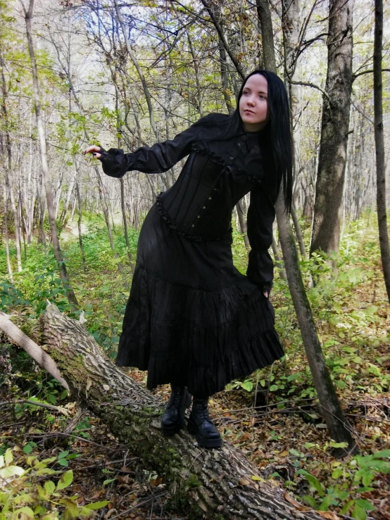 a young lady posing in a costume on a log