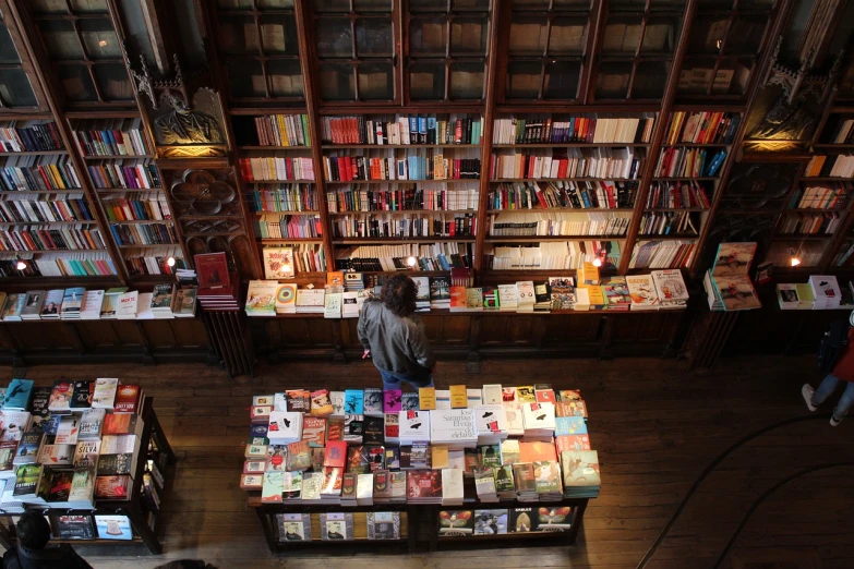 a man walking past some tables full of books