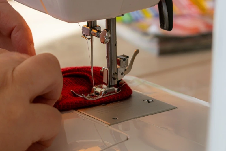 a person is sewing on the machine while they are on the table