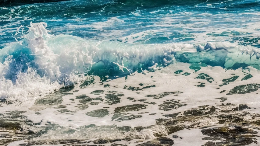 a view of the ocean from above, it's blue and white