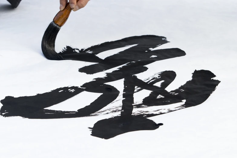 there is a person using a brush to do the oriental writing