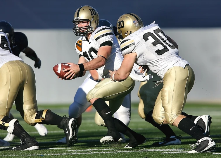 a football player in black and gold playing with a ball