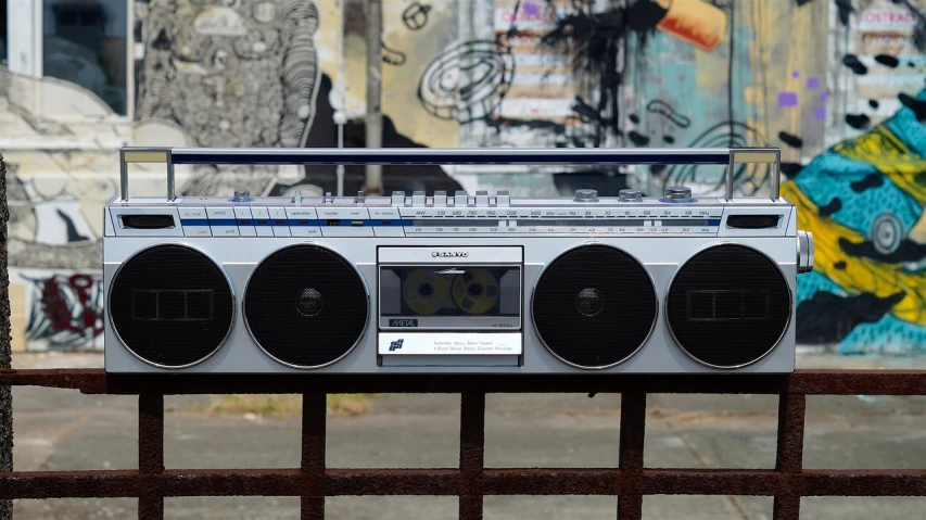 a small boombox sitting in front of a fence